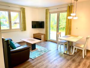 a living room with a table and a couch at River Lilly Apartment in Obertraun