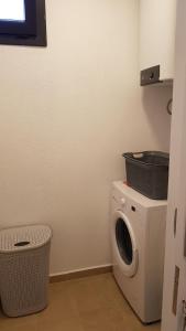 a laundry room with a washing machine and a basket at Bodrum Turgutreis Apart in Karabağ