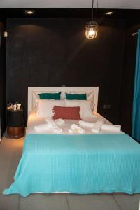 a large white bed with a blue blanket on it at Psm Luxury Living in Kánithos