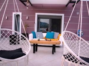 a patio with two swinging chairs and a table at Psm Luxury Living in Kánithos