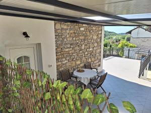 a patio with a table and chairs and a stone wall at Apartment Vignole in Portorož