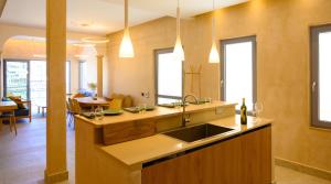 a kitchen with a sink and a dining room at Asteria Seafront Luxury Apartment in Agios Nikolaos
