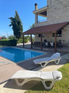 a swimming pool with two lounge chairs next to a building at Softades Cottage in Omodos