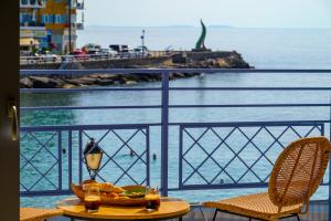 a table with a bowl of food on a balcony with the ocean at Asteria Seafront Luxury Apartment in Agios Nikolaos +24 photos