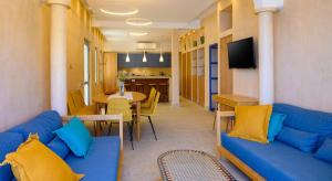 a living room with a blue couch and a dining room at Asteria Seafront Luxury Apartment in Agios Nikolaos