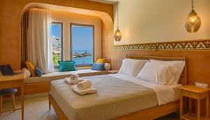 a bedroom with a bed with two towels on it at Asteria Seafront Luxury Apartment in Agios Nikolaos