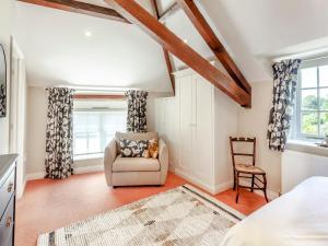 um quarto com uma cama, uma cadeira e uma janela em Beautiful Cottage In Shaftesbury With 3 Bedrooms And Wifi em Shaftesbury