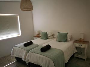 ein Schlafzimmer mit einem Bett mit zwei Kissen darauf in der Unterkunft Sipreslaan Selfsorg Gastehuis in Ladismith