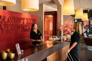 twee vrouwen aan een balie in een salon bij Hotel Vé in Mechelen