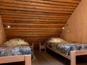 2 camas en una habitación con pared de madera en Ecological bungalow with decorative fireplace, located on a holiday farm en Heeten
