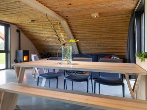 comedor con mesa de madera y sillas en Ecological bungalow with decorative fireplace, located on a holiday farm en Heeten