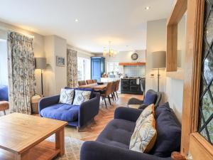 a living room with blue couches and a dining room at Fair Rigg in Sawrey
