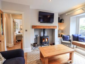 a living room with a fireplace and a table at Fair Rigg in Sawrey
