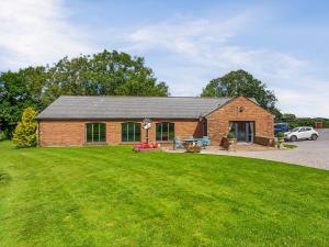 a brick building with a lawn in front of it at Halls Bank Farm in Aspatria