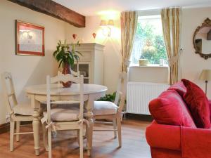 a living room with a table and a red couch at West Wood Barn in Dunnington