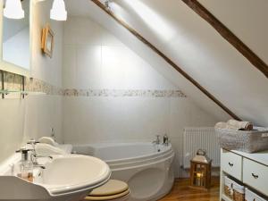 a bathroom with a white tub and a sink at West Wood Barn in Dunnington