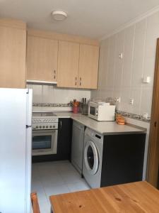 a kitchen with a stove and a washer and dryer at Casa Mariva in Arriondas