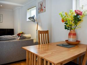 - un salon avec une table et un vase de fleurs dans l'établissement Roxys Cottage - Uk44687, à Burnopfield