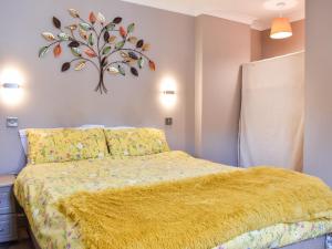 sypialnia z łóżkiem z żółtym kocem w obiekcie Roxys Cottage - Uk44687 w mieście Burnopfield