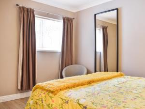 a bedroom with a bed with a mirror and a chair at Roxys Cottage - Uk44687 in Burnopfield