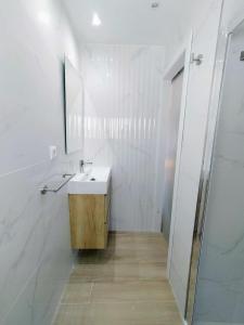 a white bathroom with a sink and a mirror at AGP Globo in Málaga
