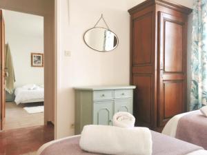 Zimmer mit einem Bett und einem Wandspiegel in der Unterkunft The Olive Press - Mon Lodge en Provence in Caromb