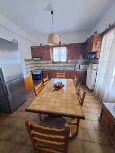 y cocina con mesa, sillas y nevera. en Cycladic House in Paros en Márpissa