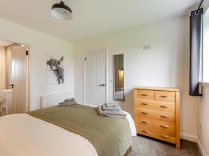 1 dormitorio con cama y tocador de madera en Balnaha Cottage en Balaldie