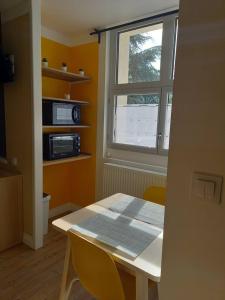 a dining room with a table and a window at La Grelauderie 1 in Saintes