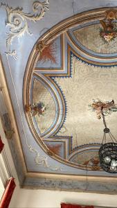 コゼンツァにあるDimora Storica Giostra Vecchia - Palazzo Grisolia 1809の天井にシャンデリアが描かれている