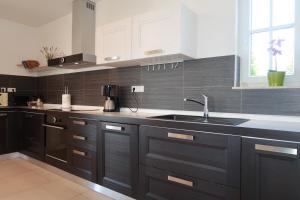 una cucina con armadi neri e lavandino di Family Villa Blum a Dobrinj