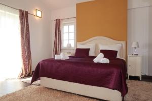 una camera da letto con un grande letto con lenzuola e cuscini viola di Family Villa Blum a Dobrinj Altre 23 foto