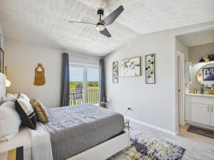 Un dormitorio con una cama y un balcón. en Palms At Cove View 806 - Bougie Beach Bungalow, en Galveston 9 fotos más
