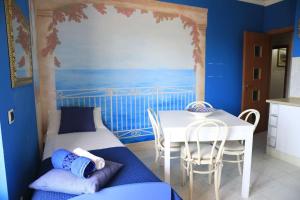 a room with a table and a bed and a table and chairs at Due minuti dal mare con Balcone in Tropea