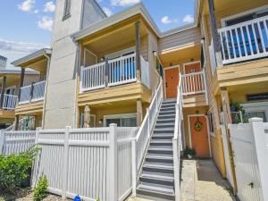 una casa con una cerca blanca y escaleras en Palms At Cove View 806 - Bougie Beach Bungalow, en Galveston