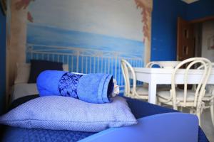 a blue room with a bed with towels on it at Due minuti dal mare con Balcone in Tropea