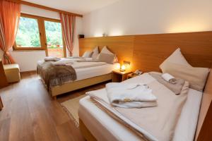 a hotel room with two beds and a window at Hotel Künstleralm in Kaprun