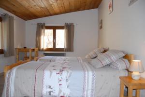 1 dormitorio con 1 cama blanca grande con almohadas en CHALET LES ECUREUILS, en Barcelonnette