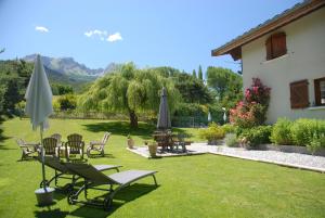 a yard with chairs and umbrellas and a house at CHALET LES ECUREUILS in Barcelonnette