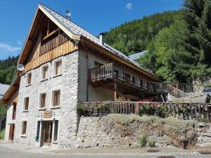a large stone building with a balcony on it at The Loft 3 minutes from Alpe dHuez Grand Domaine via Oz en Oisans in Oz