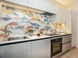 a kitchen with a sink and a mosaic wall at Below Deck in Torquay