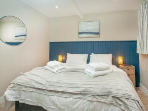 a bedroom with a large bed with towels on it at Below Deck in Torquay