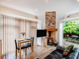a living room with a table and a fireplace at Littlemoor Barn - Uk44805 in Cloughton