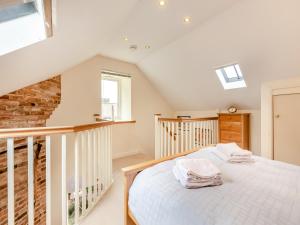 a bedroom with a white bed in a attic at Littlemoor Barn - Uk44805 in Cloughton