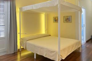 uma cama de dossel num quarto amarelo em La casa del Maestro em Palermo