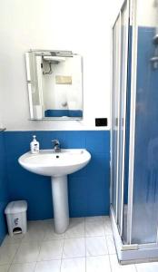 uma casa de banho com um lavatório branco e um espelho. em La casa del Maestro em Palermo