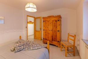 1 dormitorio con 1 cama y armario de madera en Maison Bertines II, en Casteldelfino