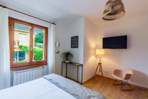 ein Schlafzimmer mit einem Bett, einem Fenster und einem Stuhl in der Unterkunft Appartamenti Le Rasole in Garda