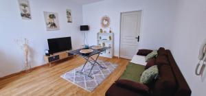 a living room with a couch and a table at Appartement NEUF chaleureux - Comme à la maison in Limoges