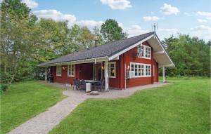 a red house with a patio in the grass at Pet Friendly Home In Kalundborg With Sauna in Kalundborg